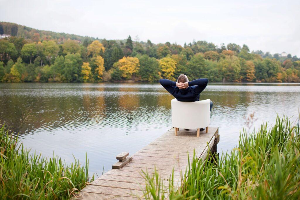 Mann entspannt am See mit Blick in die Natur.