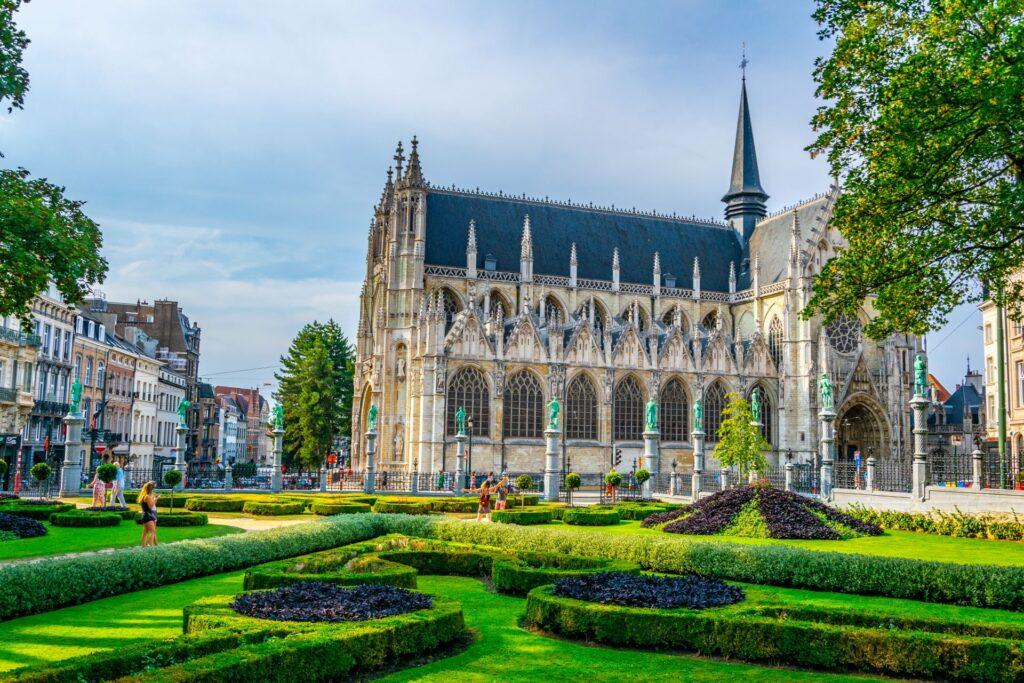Historische Kirche Notre-Dame du Sablon in Brüssel mit gepflegtem Garten im Vordergrund